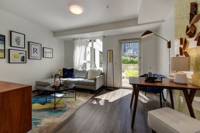Living Room with Patio Door, Hardwood Inspired Floor, White Sofa and Colorful Rug